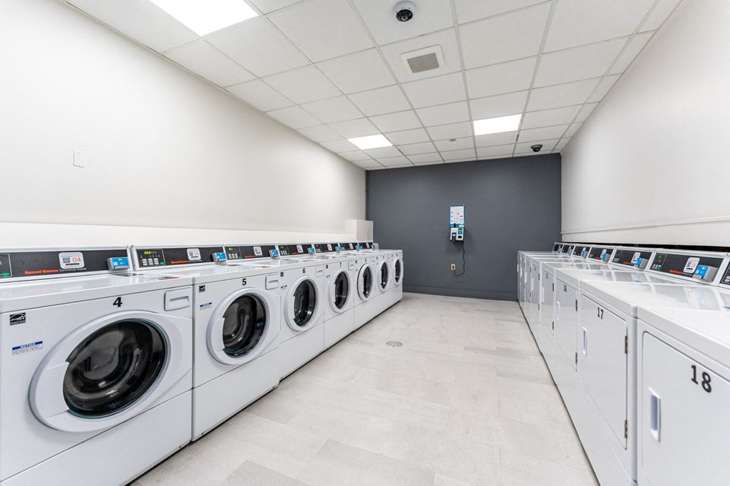a washer and dryer laundry room with rows of washes and dryers